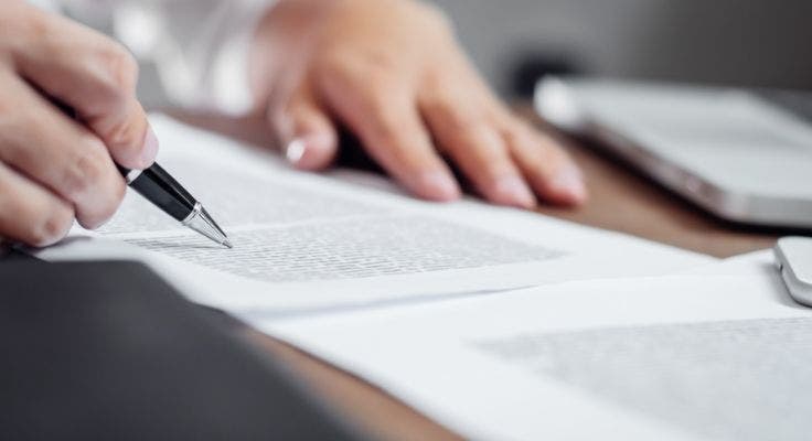 Hand with a pen and a document